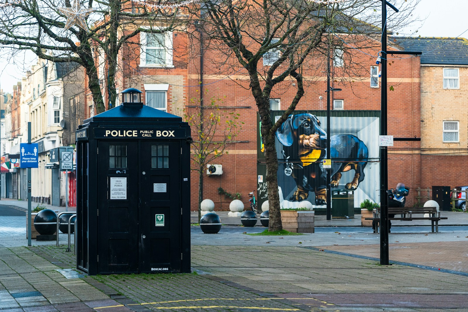 black police box on sidewalk during daytime